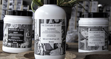 three jars and two bottles of hair care products on a rustic surface accompanied by photographs of a woman with long hair, featuring the text 