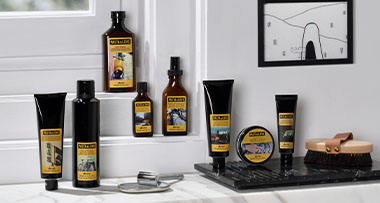 bottles of various skincare products arranged on a wooden shelf, with a decorative background showcasing intricate patterns