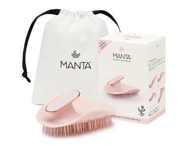 Manta hairbrush with a black design, featuring a gold accent, placed beside a white drawstring bag and a product box, showcasing its benefits for healthier hair.